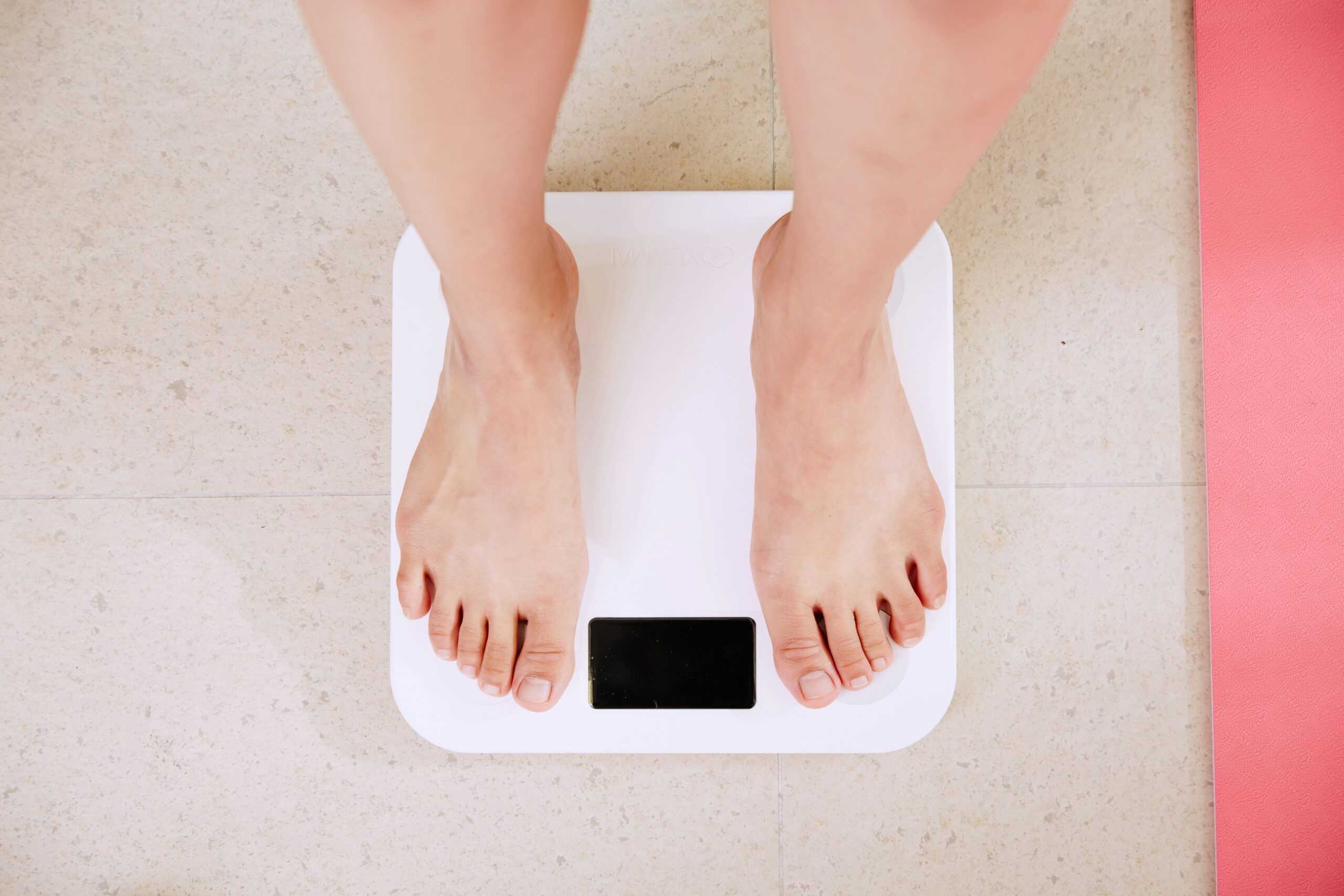 Weight-loss-myths- person-standing-on- white-digital- bathroom-scale