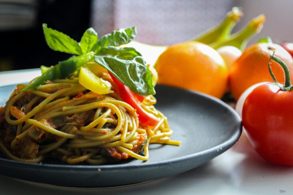 Mothers Day Gift Ideas For Self-Care 3 | eat move healthy A plate of spaghetti garnished with basil and fresh vegetables, showcasing Italian cuisine.