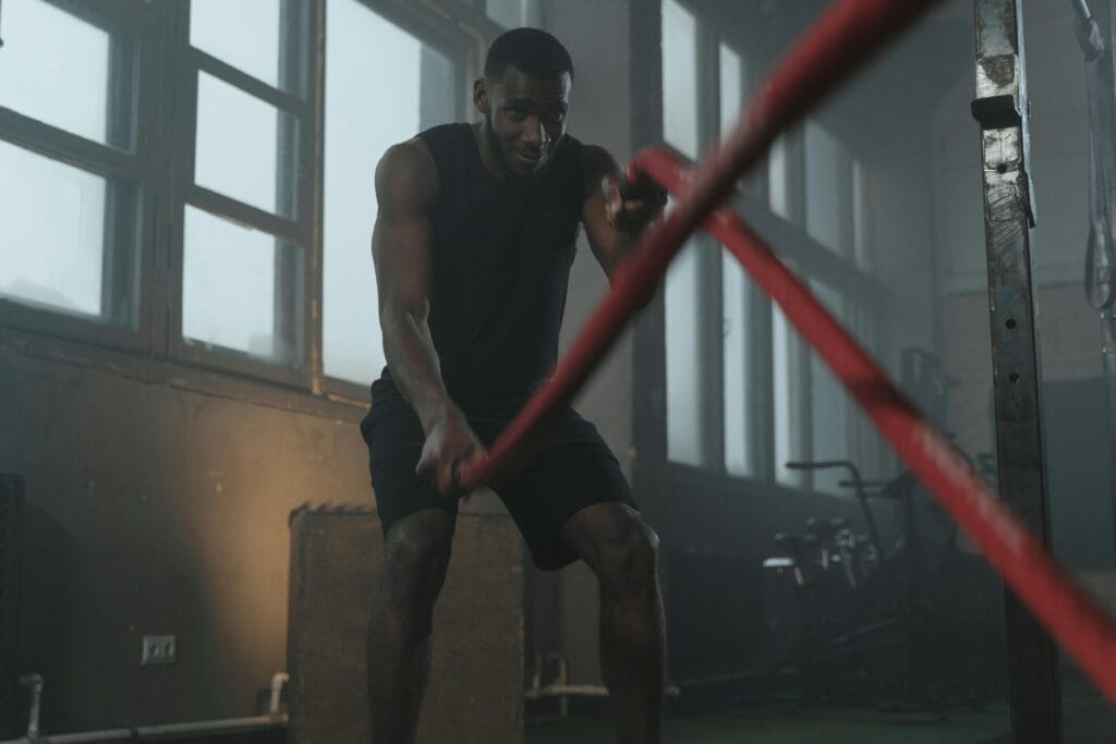 30 Day Fitness Challenge 3 | eat move healthy Fit man working out with battle ropes in a gym, showcasing strength and determination.