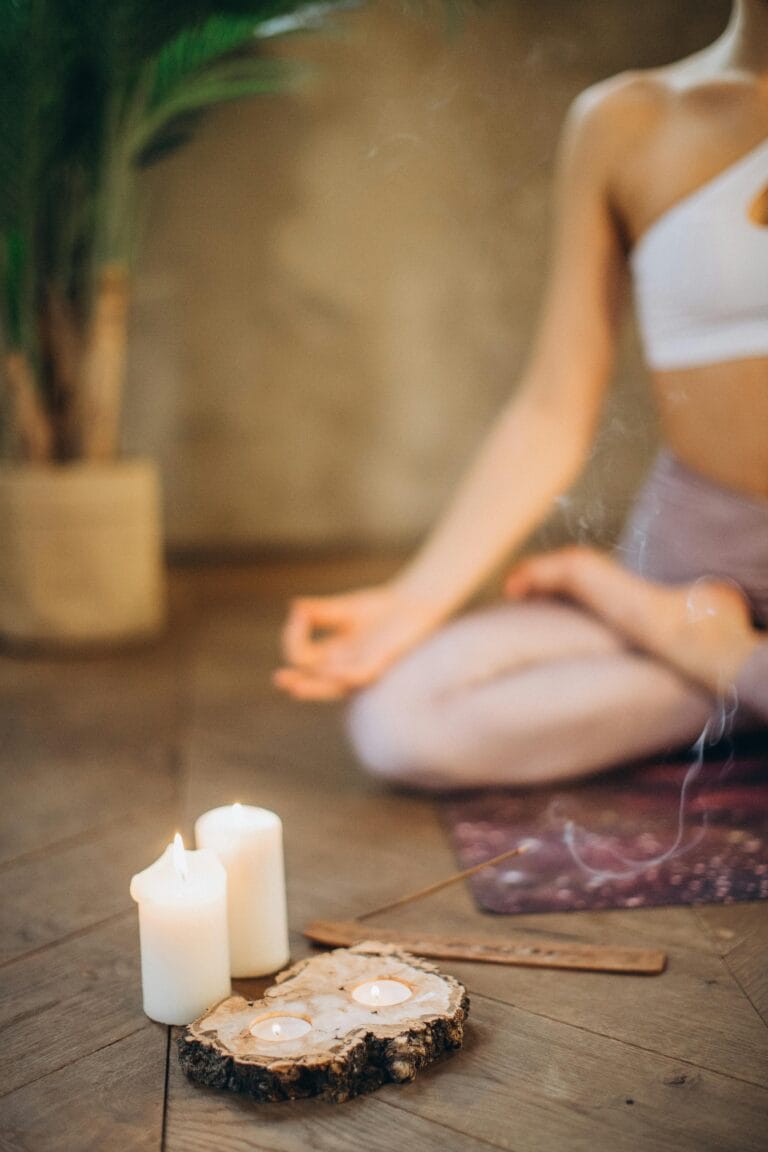 30 Day Fitness Challenge 6 | eat move healthy Woman practicing meditation in lotus pose with candles and incense, focusing on wellness and relaxation.