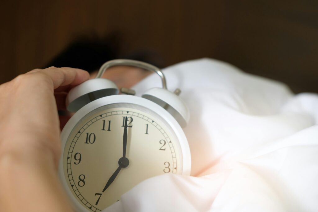 10 Surprising Health Facts You’ve Never Heard 8 | eat move healthy A close-up of a hand reaching for a ringing alarm clock, symbolizing waking up in the morning.