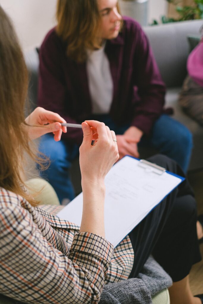 How to Cope with Anxiety 3 | eat move healthy A therapist with a clipboard conducting a counseling session with clients.