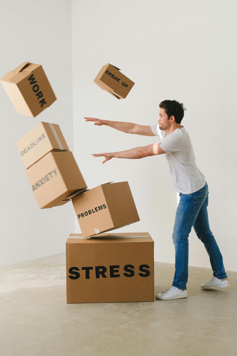 How to Cope with Anxiety 1 | eat move healthy Full body of young man in sneakers and jeans pushing and falling boxes saying Work Problems Anxiety Stress and Deadline while fighting with problems
