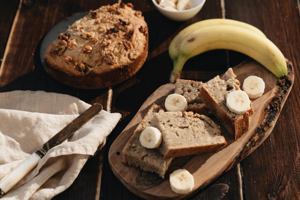 5 Steps Efficient Healthy Meal Planning 5 | eat move healthy A rustic presentation of homemade banana bread with fresh bananas on a wooden board.