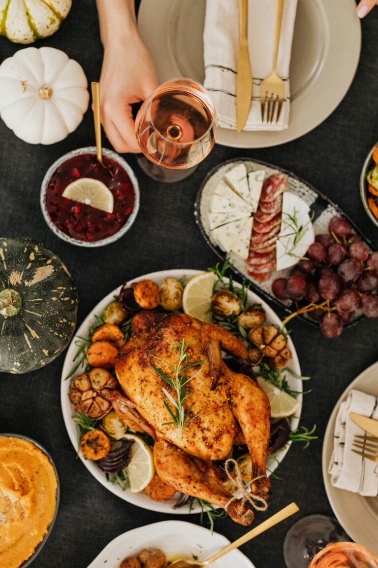 How to Avoid Holiday Weight Gain 1 | eat move healthy Top-down view of a Thanksgiving feast featuring roasted chicken, sides, and wine.