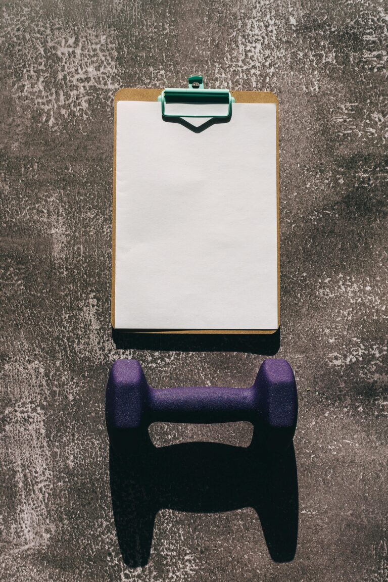 How to Avoid Holiday Weight Gain 3 | eat move healthy Mockup of a fitness plan using a clipboard and dumbbell on a textured background.